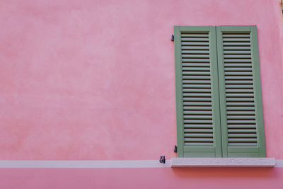 Close-up of pink window on wall of building