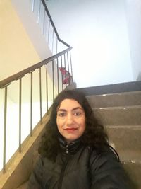 Portrait of smiling young woman on staircase