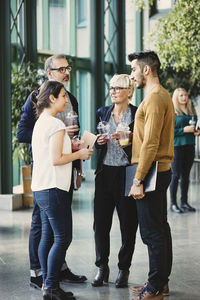 Full length of business people having discussion in creative office