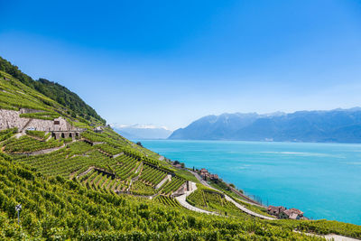 Scenic view of sea and mountains against blue sky