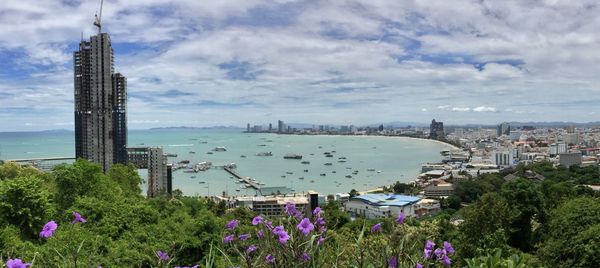 High angle view of buildings by bay against cloudy sky