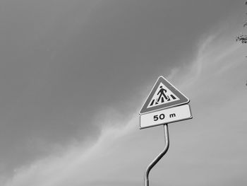 Low angle view of road sign against sky