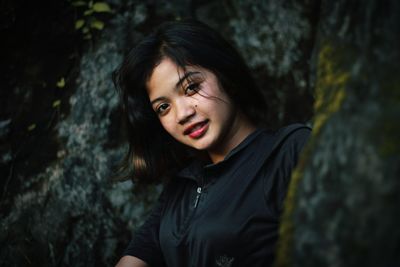 Portrait of beautiful young woman against trees