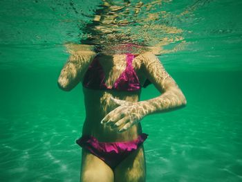Midsection of girl swimming in sea