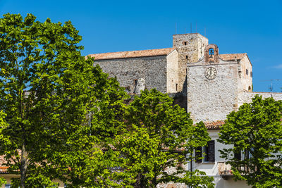 Low angle view of old building against clear blue sky