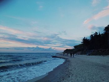 Scenic view of beach against cloudy sky