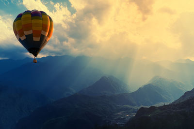Hot air balloons in mountains against sky