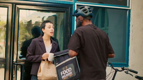 Rear view of young woman standing in bus