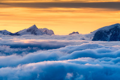 Scenic view of snowcapped mountains against sky during sunset