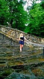 Full length of woman standing in forest