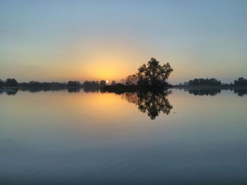 Scenic view of lake against sky at sunset