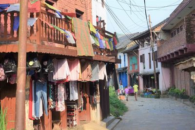 Clothes drying on alley amidst houses against buildings