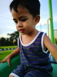 Low angle view of cute boy on slide