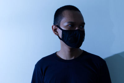 Portrait of young man against blue background