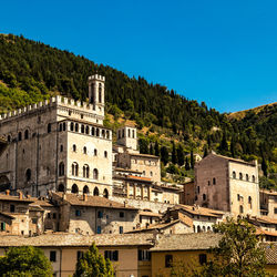 Buildings in city against clear blue sky