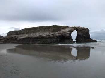 Rock formation in sea against sky