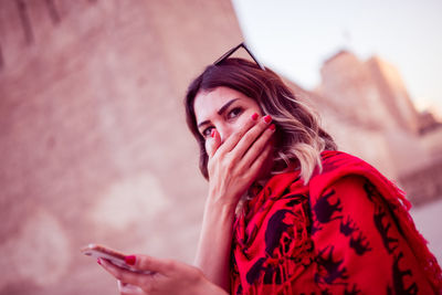 Portrait of young woman using smart phone outdoors