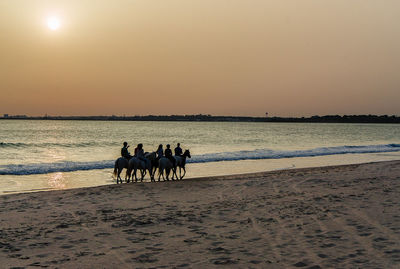 People on beach at sunset