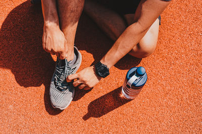 Low section of man tying shoelace outdoors