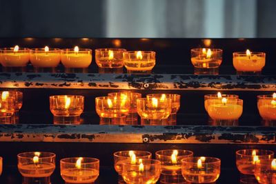 Illuminated tea light candles in building