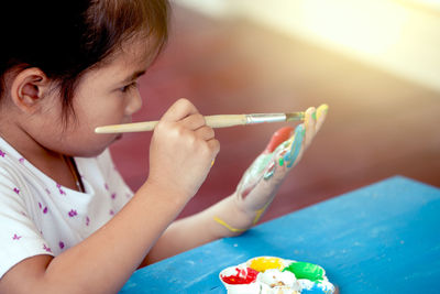 Close-up of girl painting on hand