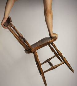 Asian male handstand balancing on simple wooden asian chair