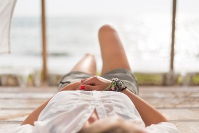 Low section of woman relaxing at beach