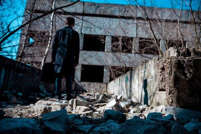 Rear view of man standing by old building