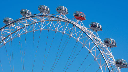 Low angle view of ferris wheel against clear blue sky