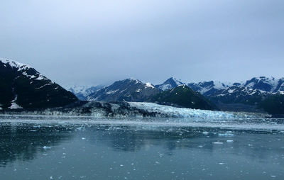 Scenic view of lake against mountains during winter