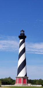 Low angle view of lighthouse by building against sky