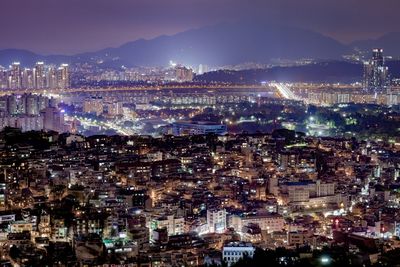 Illuminated cityscape against sky at night