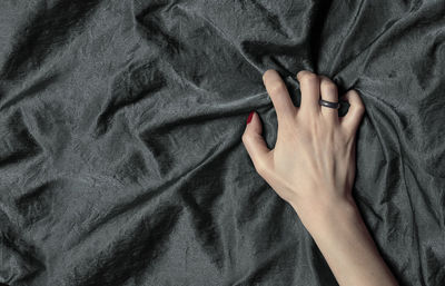 Close-up of woman hand on bed