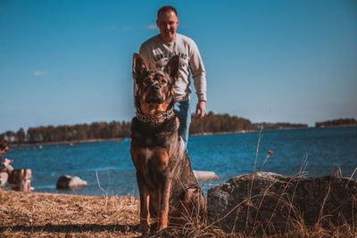 Full length of man with dog against sky