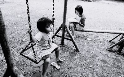 Rear view of boy swinging at playground