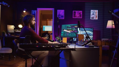 Rear view of woman using laptop on table