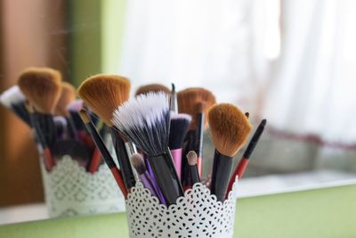 Close-up of various make-up brushes in desk organizer