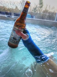 Man holding bottle in swimming pool