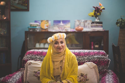 Portrait of bride wearing traditional clothing sitting at home