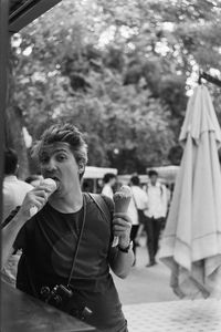 Young man eating ice cream on the street 