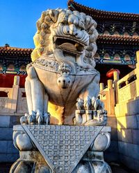 Low angle view of statue against built structure