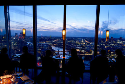 Group of people in city buildings against sky