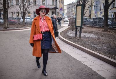 Full length portrait of woman in city during winter