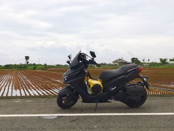 Man riding motorcycle on road against sky