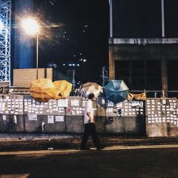 Woman standing on road at night