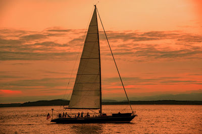 Sailboat in sea against sky during sunset