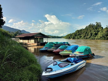 Boats moored on lake against sky