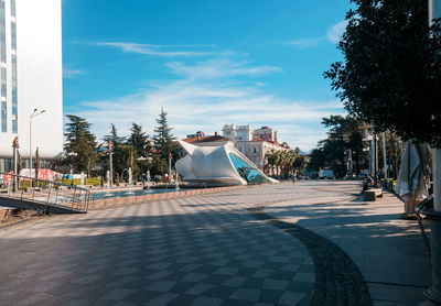 View of city street against cloudy sky