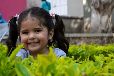 Portrait of cute girl smiling amidst plants