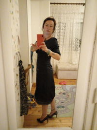 Full length portrait of woman standing at home